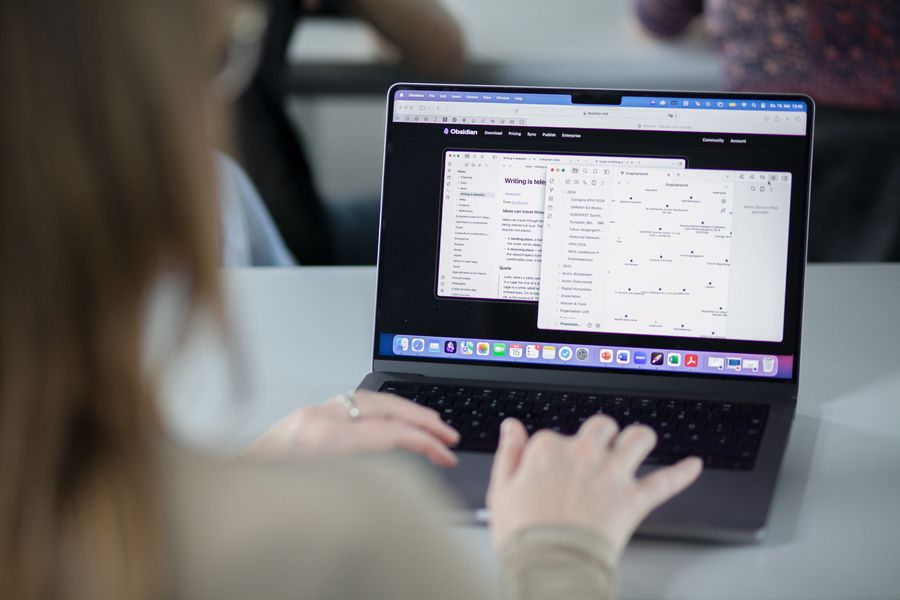 Person working at a desk with laptop and notes